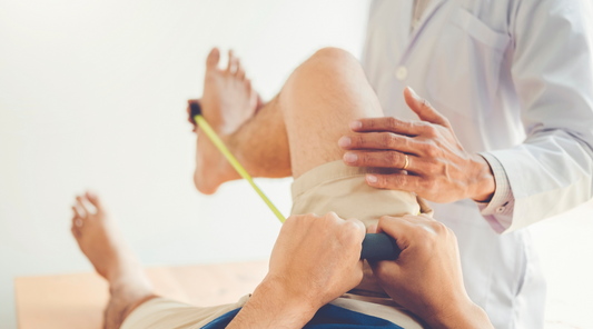 A physical therapist assisting to perform and exercise using a physical therapy resistance band. 